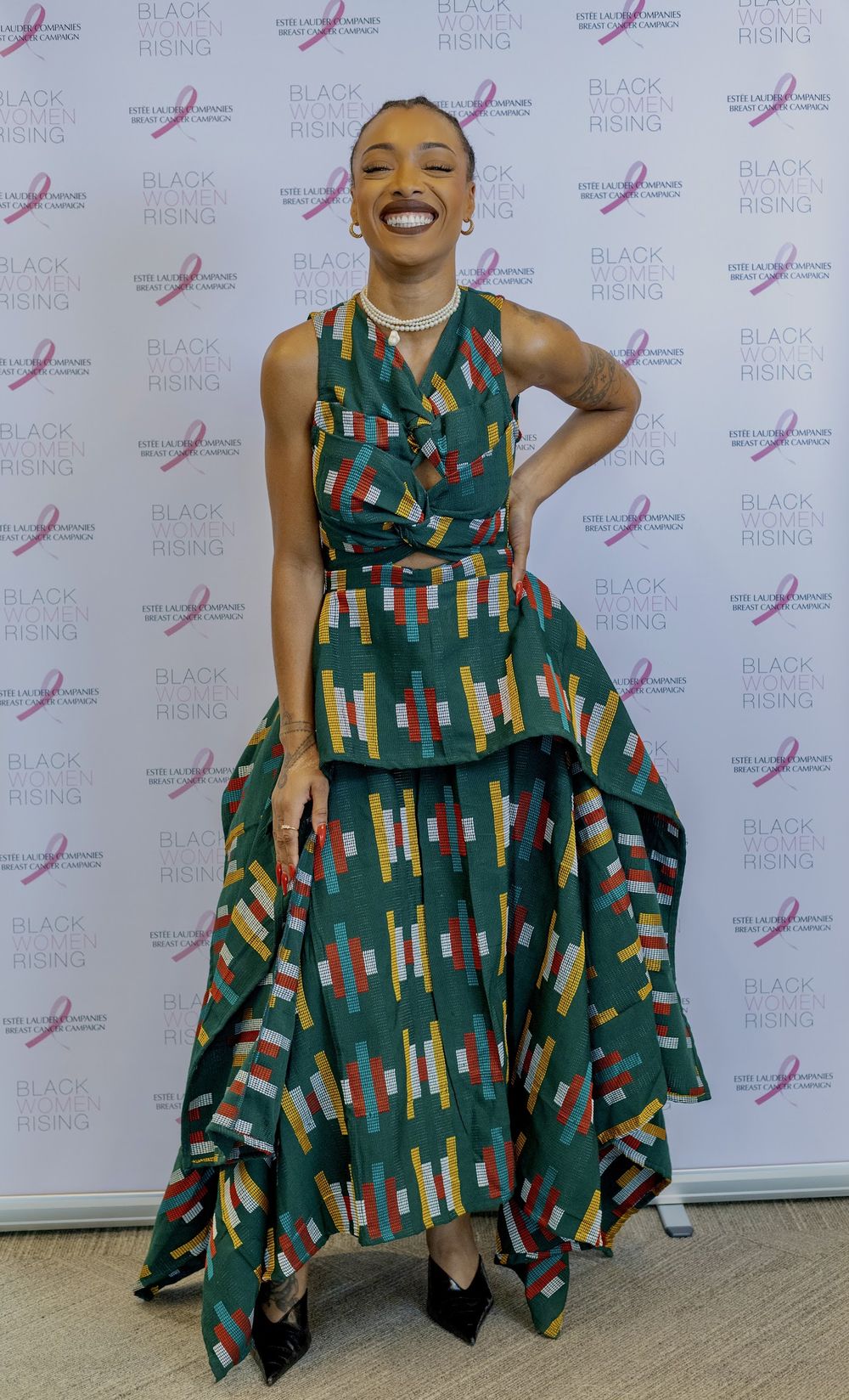 Paige smiling in a green patterned dress at an event
